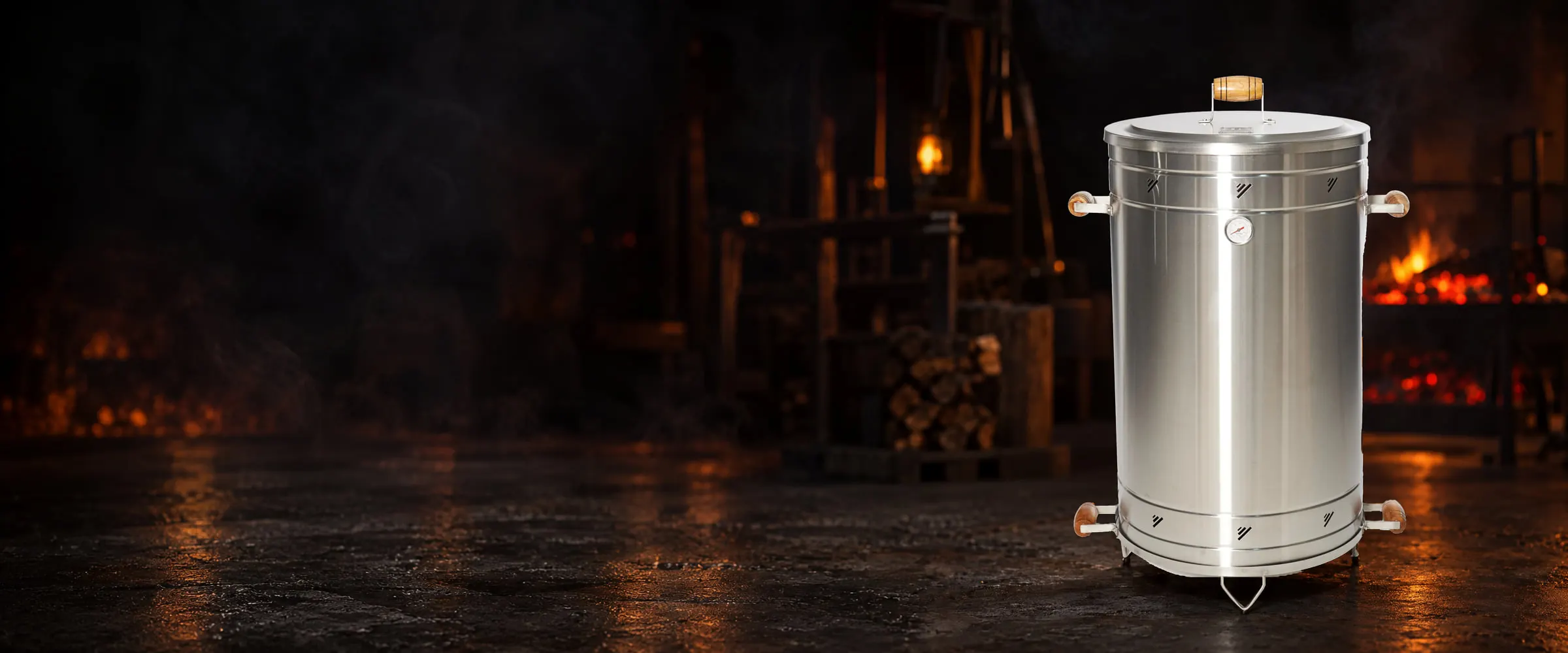 Santo Carbón steel barrel smoker on a workshop floor, with glowing coals in the background